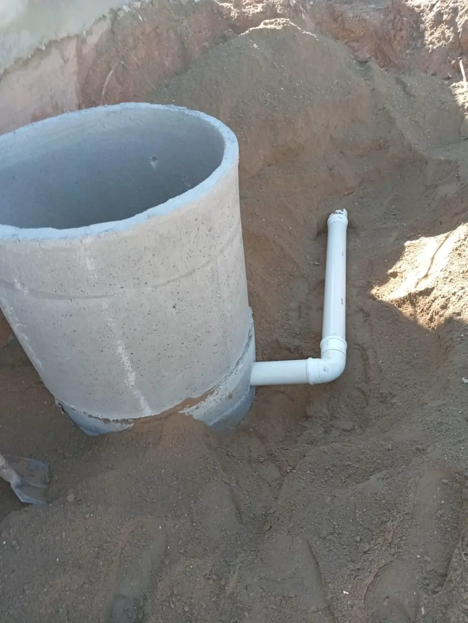 Caixa de passagem de concreto com tubulação